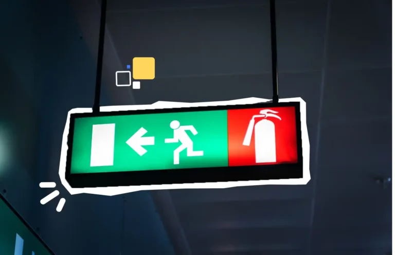 Panneau lumineux d’évacuation et extincteur indiquant la sortie de secours, illustrant la formation sécurité incendie et évacuation en entreprise – Axio-Protech