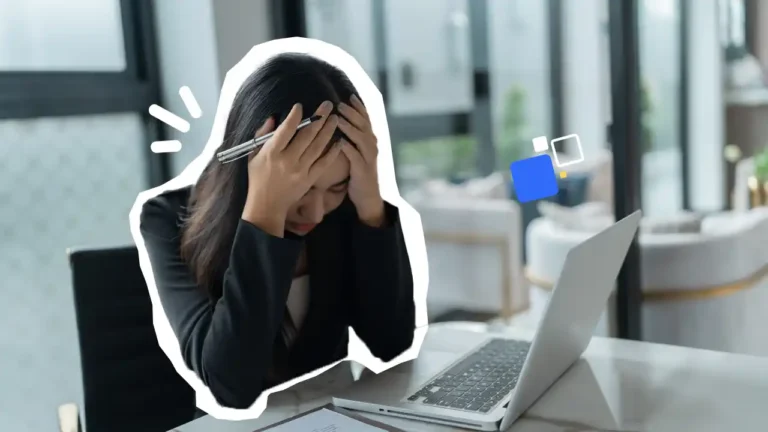 Employée assise à son bureau, la tête dans les mains face à son ordinateur portable, illustrant la fatigue mentale et la prévention du burn-out au travail – Formation RPS Axio-Protech