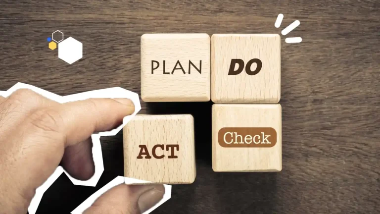 Main plaçant des cubes en bois affichant les mots Plan, Do, Check, Act, représentant le cycle PDCA appliqué à la prévention et à l’amélioration continue en entreprise.