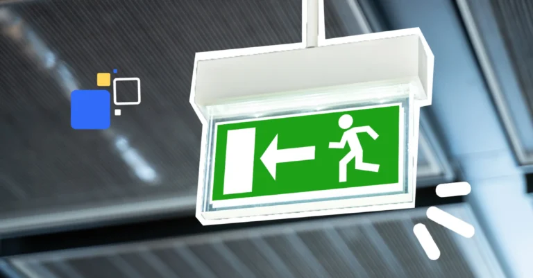 Panneau lumineux de sortie de secours indiquant une évacuation vers la gauche, suspendu au plafond d’un bâtiment.